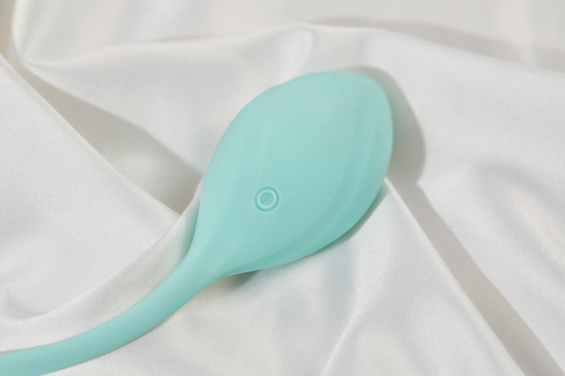 Hand holding a lemon vibrator above a decorative bowl, representing modern intimacy tools
