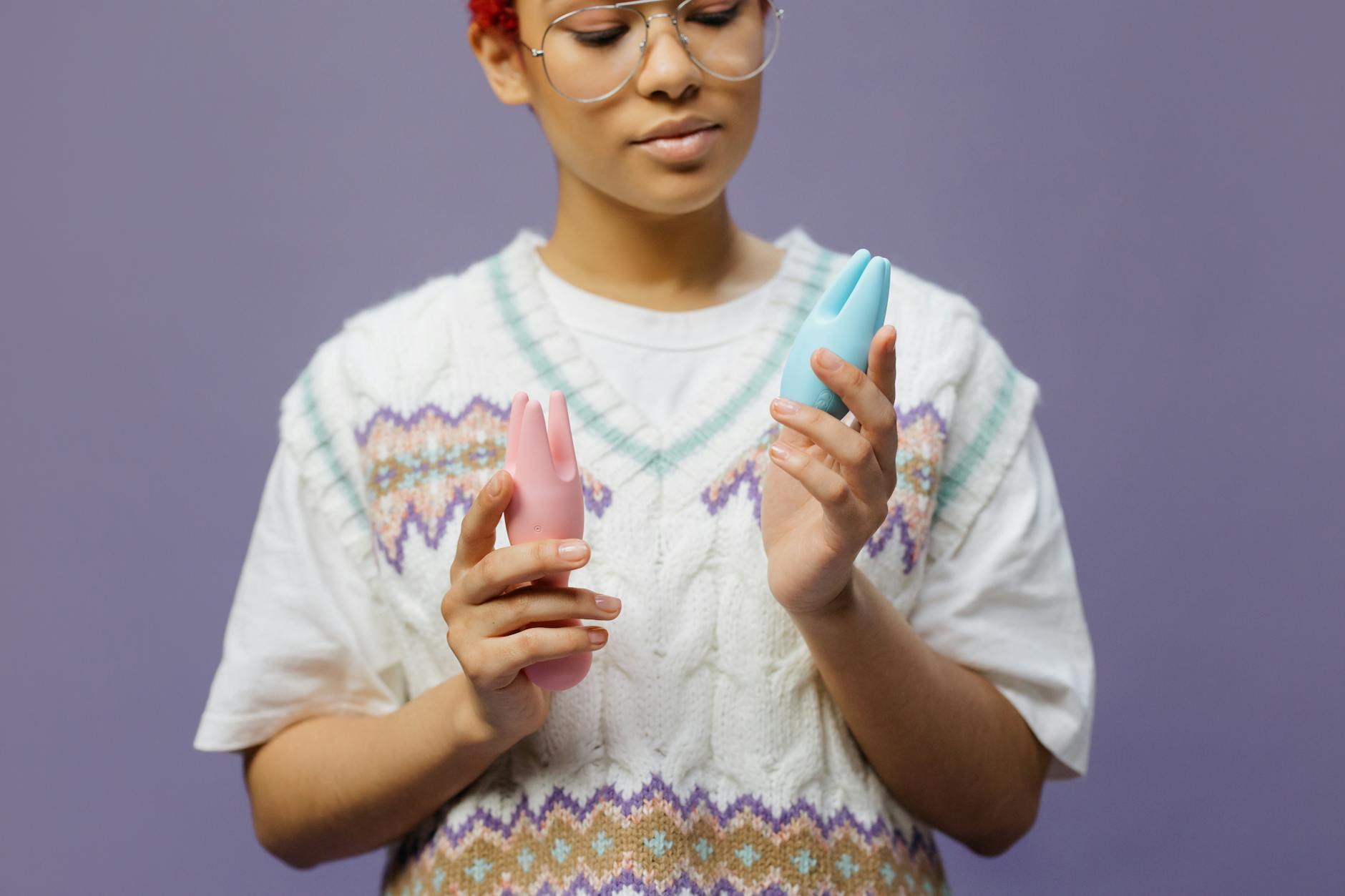Woman holding a blue clitoral vibrator in a moment of self-care and body reclamation.