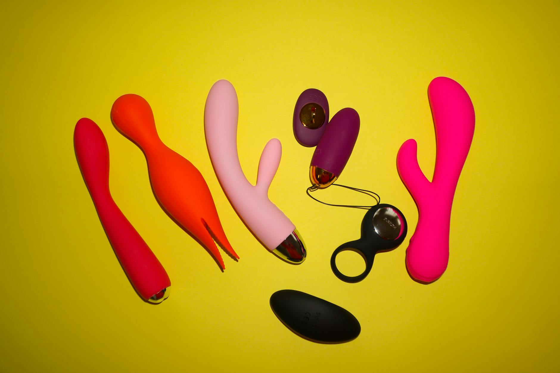 Close-up of a hand holding a vibrator against a minimalistic purple backdrop